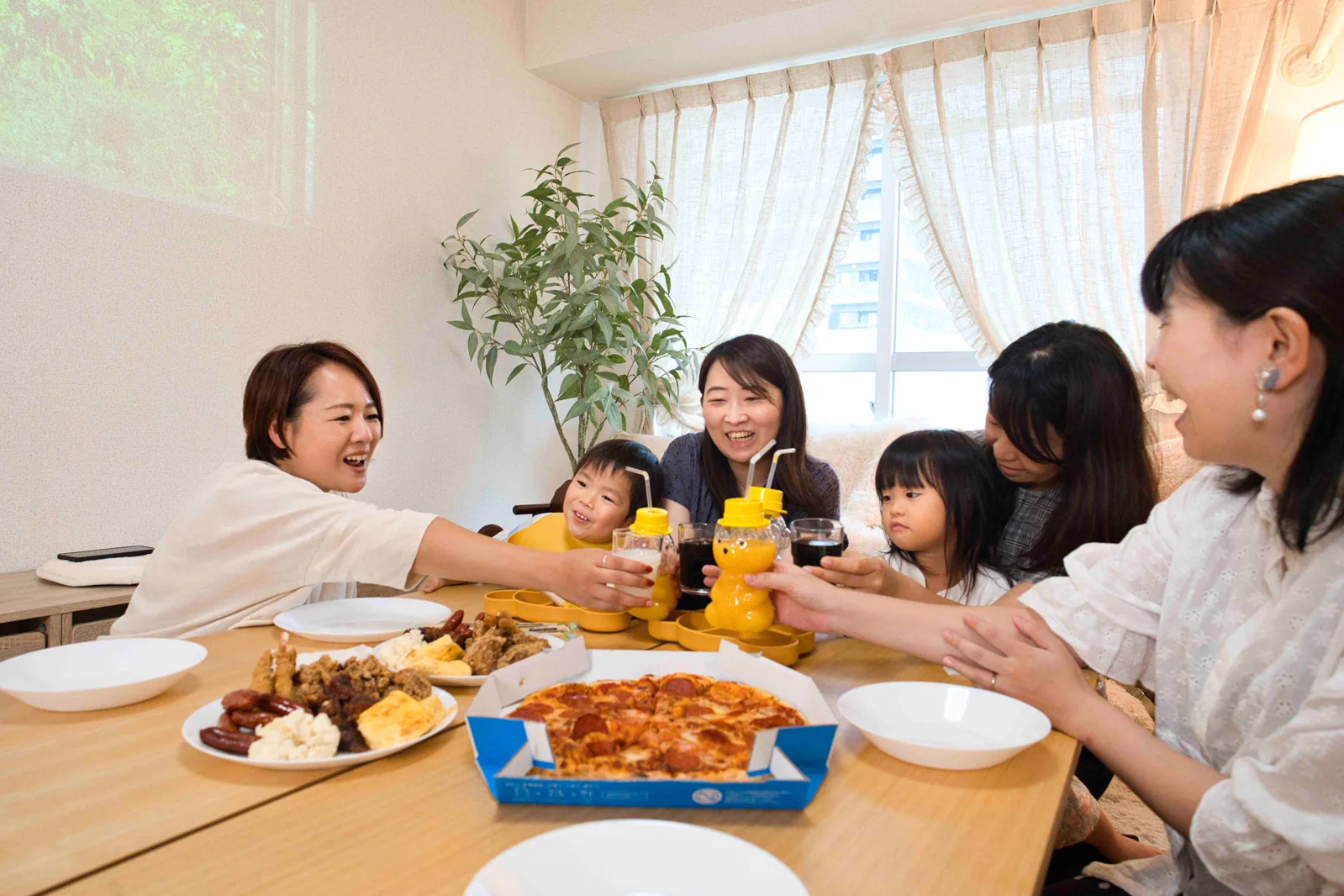 テーブルを囲んで食事を楽しむ親子会の様子。欠席時の食事量や会費の調整を考える参考イメージ